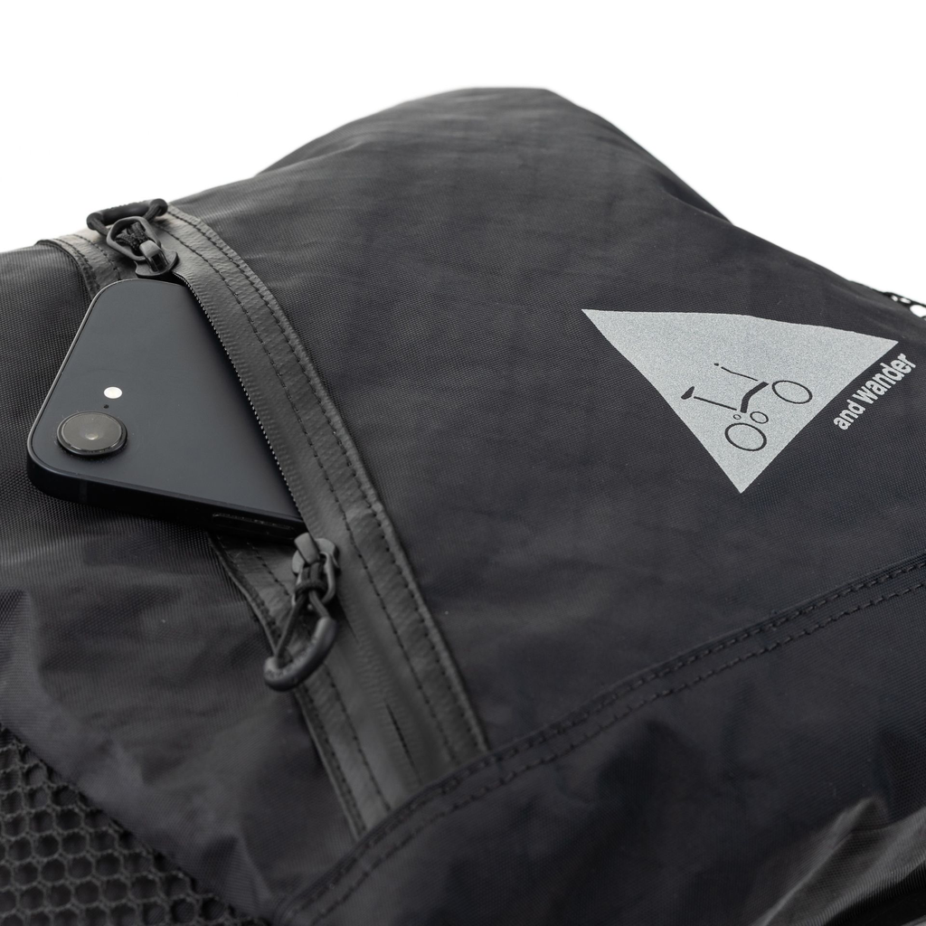 Brompton x and wander backpack showing phone in front zip pocket - stock photo.webp